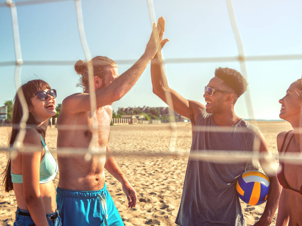 Group of friends playing at beach volley at the beach - Photo, Image