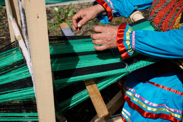 Un exemple de l'utilisation d'un métier à tisser artisanal est une femme âgée
.  - Photo, image
