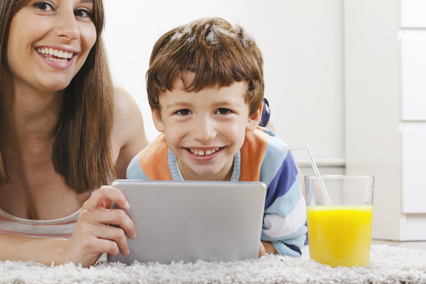 Madre e hijo se divierten con una tableta digital en casa
 - Foto, Imagen