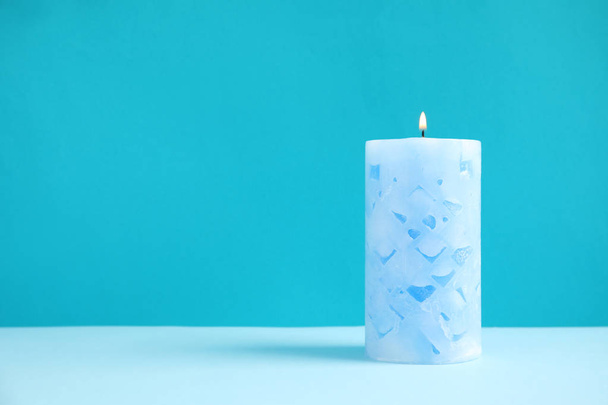 Alight wax candle on color background. Space for text - Φωτογραφία, εικόνα