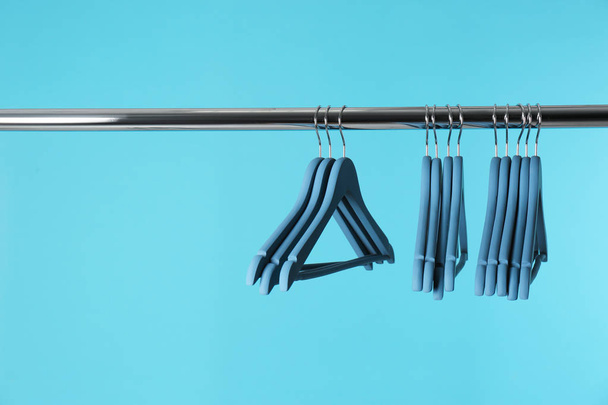 Metal rack with clothes hangers on color background, space for text - Фото, зображення