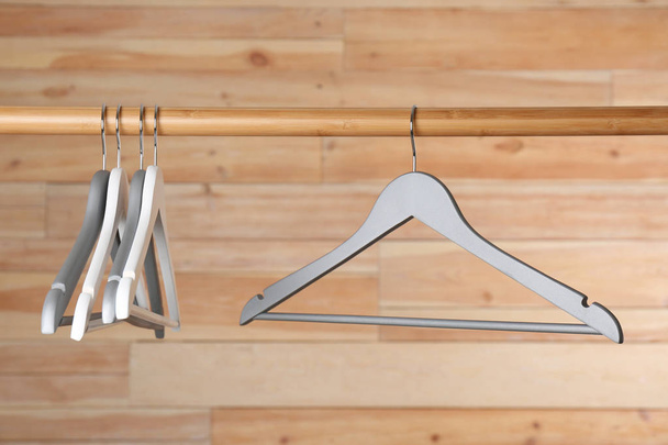 Rack with clothes hangers on wooden background - Фото, зображення
