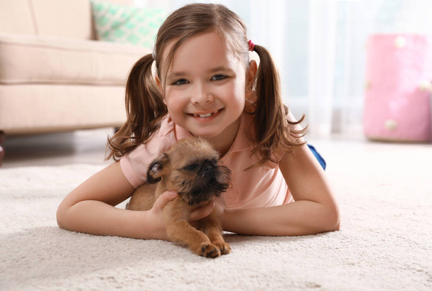 Portrait of cute girl with funny Brussels Griffon dog at home. Loyal friends - Foto, Imagen