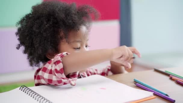 Afrikkalainen lapset piirustus ja tehdä kotitehtäviä luokkahuoneessa, nuori tyttö onnellinen hauska opiskella ja pelata maalaus paperilla peruskoulussa. Lasten piirustus ja maalaus koulussa käsite
. - Materiaali, video