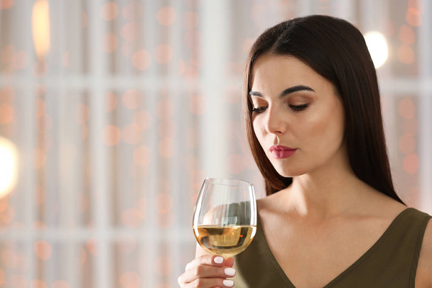 Beautiful young woman with glass of luxury white wine indoors. Space for text - Fotografie, Obrázek