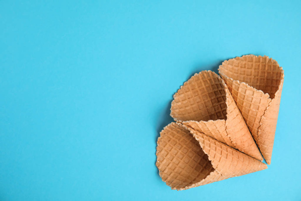Waffle empty ice cream cones on color background, flat lay. Space for text - Photo, image