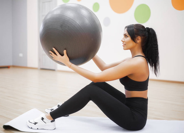 Mujer de fitness. Joven atractiva mujer haciendo flexiones usando pelota
 - Foto, Imagen