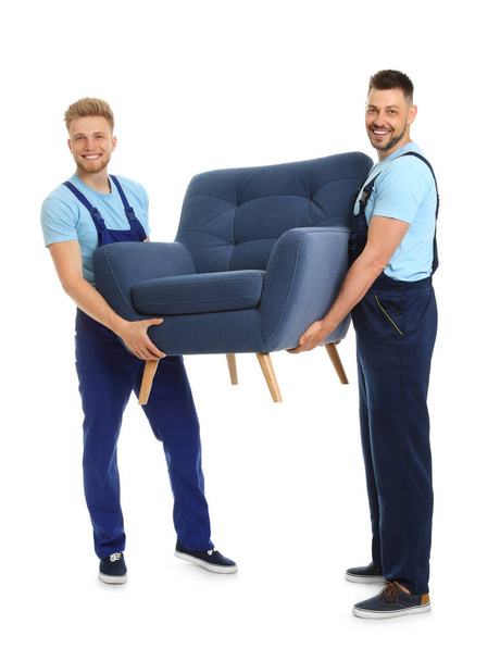 Portrait of moving service employees with armchair on white background - Fotó, kép