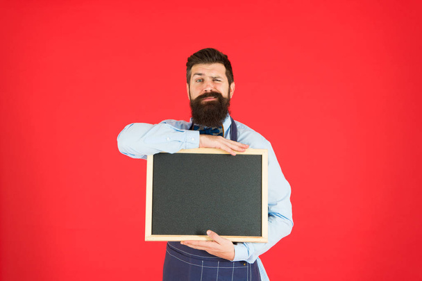 professional chef. great cuisine. cooking by recipe. welcome. Restaurant or cafe advertising. menu board. happy man chef with blank blackboard, copy space. professional bearded hipster cook in apron - Фото, изображение