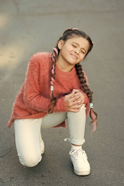 shouting little girl in autumn sweater. Small child has pain in knee. Autumn snuggles. Autumn fashion for pretty girl. healthy childhood. leg injury of little girl. need some help. oh my god. - Fotoğraf, Görsel