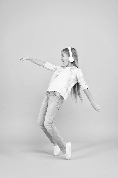 The happiest song she knows. Happy small girl dancing to music. Small girl listening to music in headphones. Cute child enjoying happy dance music. Dancing girl. Music is happiness for her - Fotografie, Obrázek