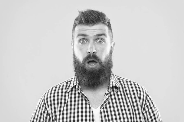 Guy surprised face expression. Hipster with beard and mustache emotional surprised expression. Rustic surprised macho. Surprising news. Man bearded hipster wondering face yellow background close up - 写真・画像