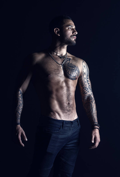Bodycare with fitness and sport. Tattooed man show sexy muscular torso. Sportsman with six pack and ab. Bodybuilder with biceps and triceps. Fashion model with tattoo in jeans - Fotoğraf, Görsel