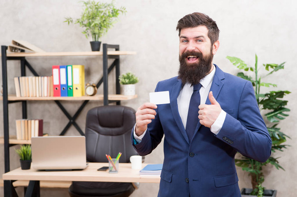 Card design. Guy formal suit stand in office. Businessman hold blank card. Useful contacts. Bearded hipster top manager show card. Banking services. Private lawyer. Call me if you have any questions - Foto, afbeelding