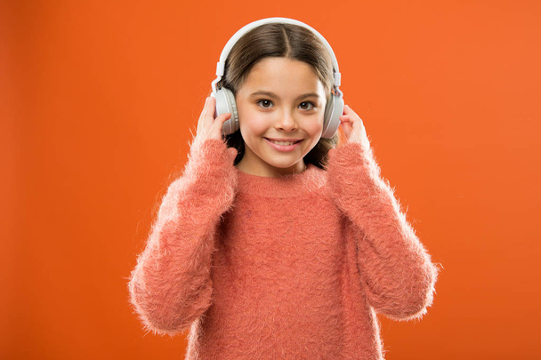 A new audio technology is coming. Little girl wearing wireless stereo headphones. Modern technology. Technology and music. Stereo sound technology - Фото, изображение