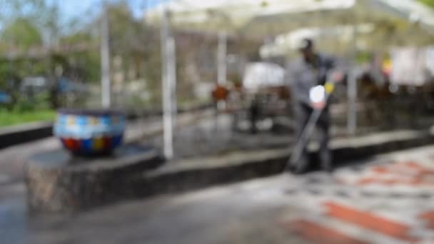 Mies työntekijä siivoamassa kaupungin likaisia katuja
 - Materiaali, video