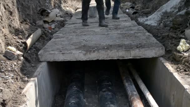 Arbeiter mit Baukran bedecken neue Wasserleitungen mit Betonplatten - Filmmaterial, Video