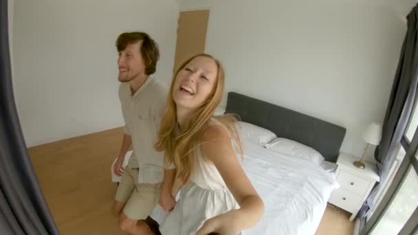 Slowmotion shot of a happy couple man and woman fall on a bed. Travel concept. Honeymoon concept - Filmagem, Vídeo