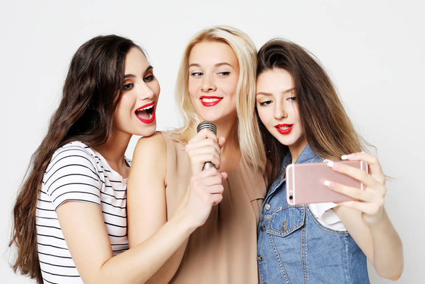beauty girls with a microphone singing and having fun together  - Zdjęcie, obraz