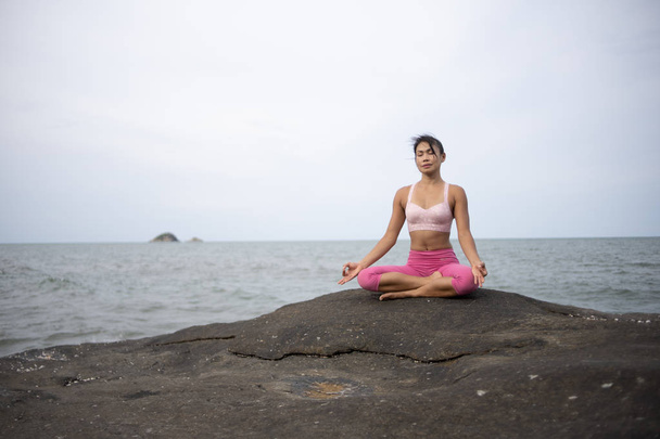 Asian girl practice Yoga on the beach Sunrise morning day - Zdjęcie, obraz