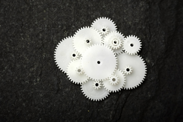 White wheel gears are on black texture background - Fotoğraf, Görsel