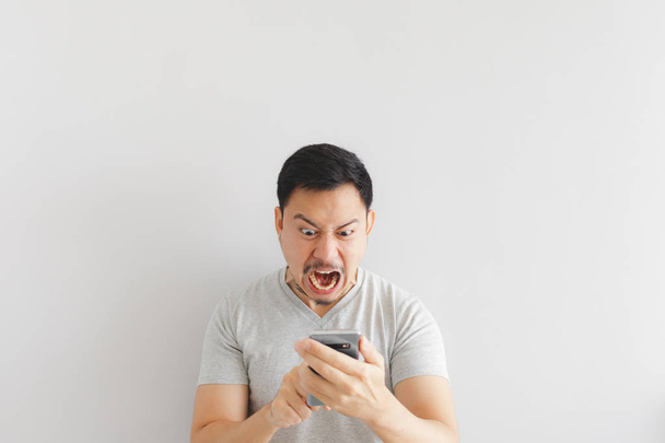 Angry man in grey t-shirt get mad on the smartphone. - 写真・画像