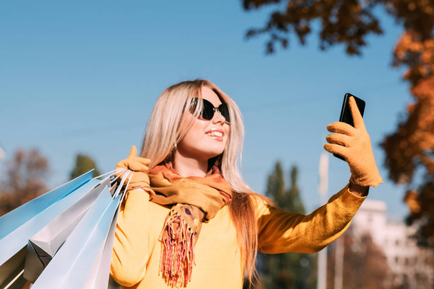 fall park walk shopping bags smartphone selfie - Foto, Imagen