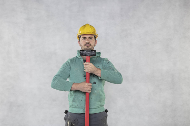 le travailleur de la construction tient un marteau, prêt pour la démolition
 - Photo, image