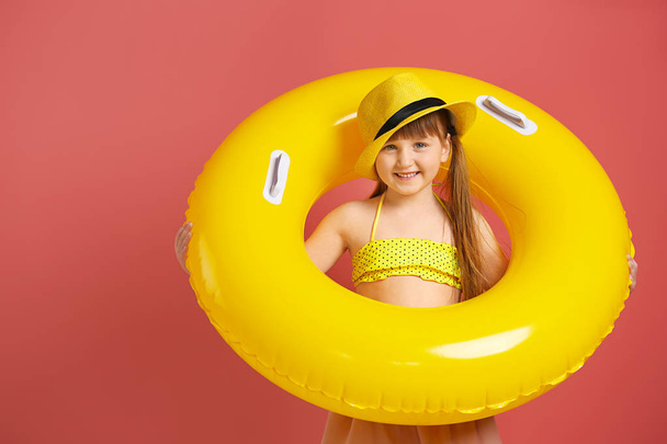 Cute little girl with inflatable ring on color background - Fotó, kép