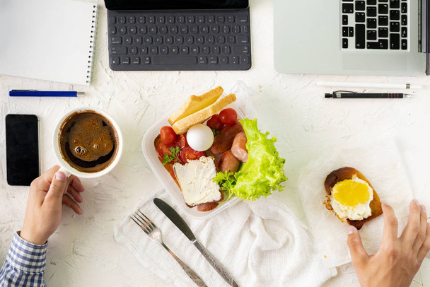 jovem do sexo masculino tomando refeição na frente do laptop enquanto trabalhava, maus hábitos e conceitos de obesidade - Foto, Imagem