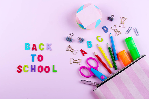 Back to school concept. School supplies in pencil case. Pink background. Flat lay, view from above. - Zdjęcie, obraz