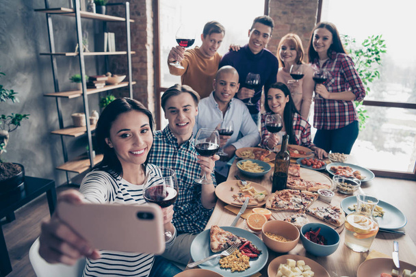 Close up photo friendly event together diversity different race guys raise glasses red beverage telephone make take tradition selfies sit table shirts sweater pullover loft cafe restaurant indoors - Foto, Bild