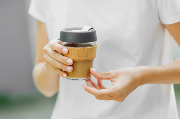 Female hands hold reusable coffee mug. Take your coffee to-go with reusable travel mug. Zero waste. Sustainable lifestyle concept - Foto, immagini