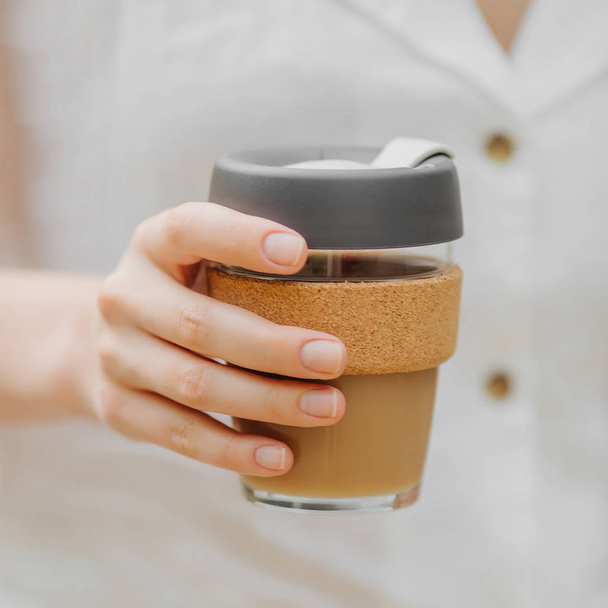 女性の手は再利用可能なコーヒーマグを保持します。持続可能なライフスタイル。環境にやさしいコンセプト. - 写真・画像