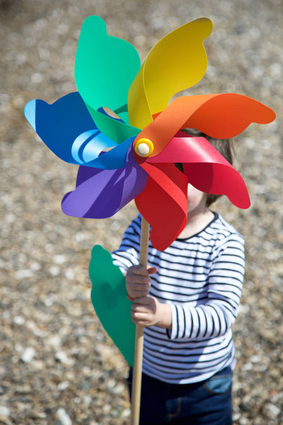 Menino segurando pinwheel colorido
 - Foto, Imagem