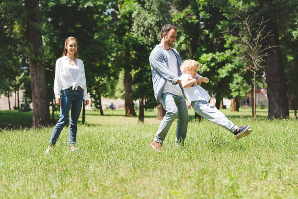 family spending time together, father spinning son in park - Photo, Image