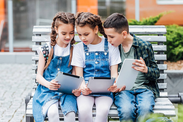 Three cute children using digital tablets, focus on foreground - Photo, Image