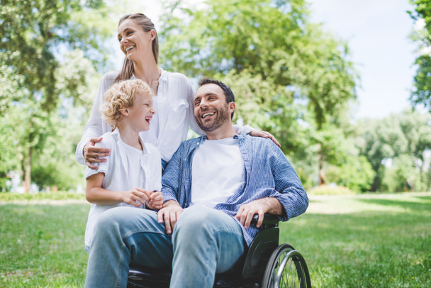 happy family with disabled father on wheelchair in park - Fotografie, Obrázek