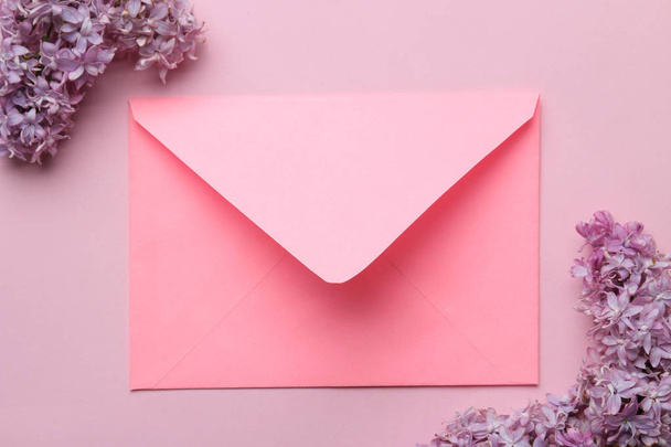 Pink envelope and branch of lilac on a bright trendy pink background. top view - Foto, Bild