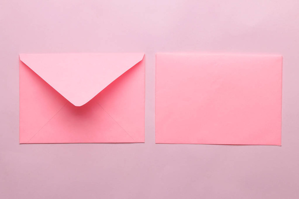 明るいトレンディなピンクの背景にテキストのための空白のピンクの封筒。トップビュー - 写真・画像