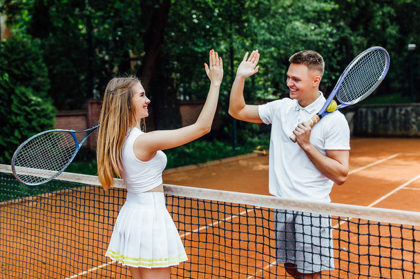 Couple handshaking at tennis court after playing game - Фото, зображення