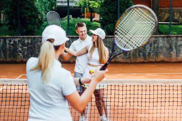 Portrait of woman playing in tennis with trainer - Foto, imagen