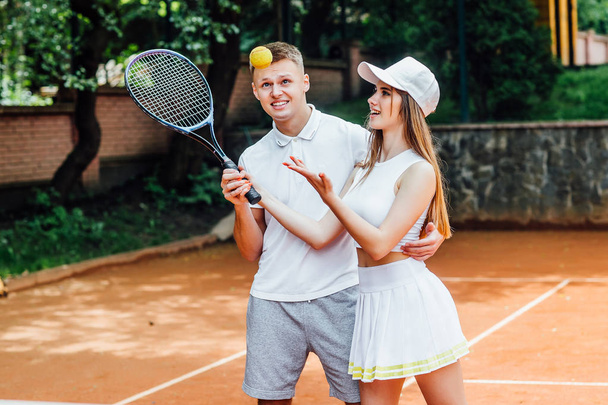 Athletic woman and man holding racquets and wearing uniforms - Foto, Bild