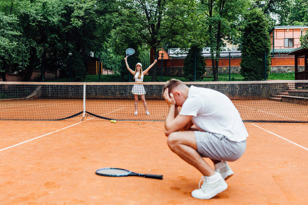 young couple playing tennis game outdoor, man losing   - Fotó, kép