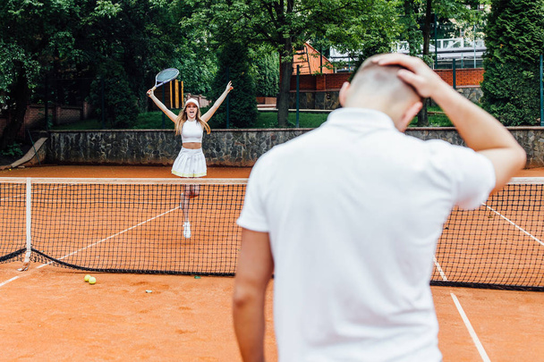 young couple playing tennis game outdoor, man losing  - Φωτογραφία, εικόνα