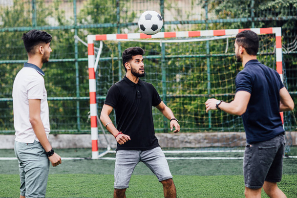 handsome men playing football on field togetherness - Фото, изображение