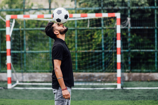 Football player hitting ball with head on field  - Fotografie, Obrázek