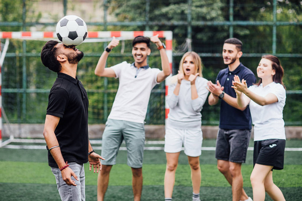 Fußballer spielt Kopfstoß, Freunde im Hintergrund - Foto, Bild