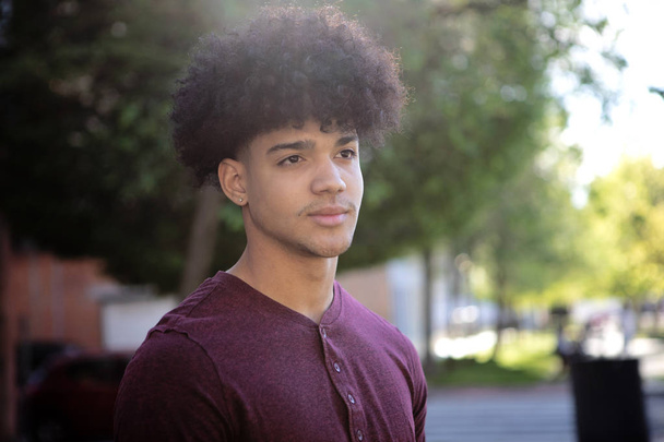 adolescente masculino con peinado afro en la calle
 - Foto, imagen