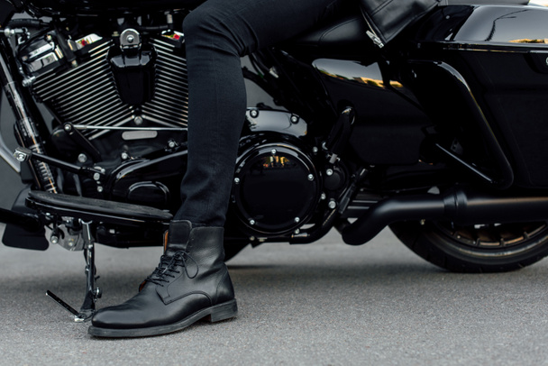 vista cortada do homem na bota preta sentado na motocicleta
 - Foto, Imagem